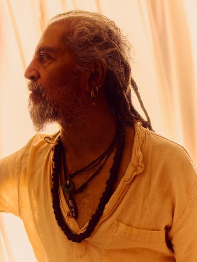 Elder with long greying dreadlocks in profile, soft side light.